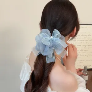 Chouchou en organza bleu clair avec perles et détail de nœud ruban, accessoire élégant.