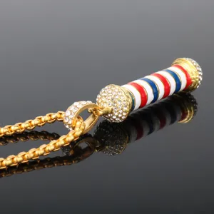 Collana con ciondolo palo da barbiere dorato con strass scintillanti e strisce colorate.