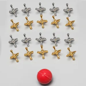 Metal jacks game set with gold and silver pieces and a red bouncing ball for desktop fun.