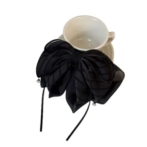 Élégante pince à cheveux nœud en maille rayée noire, griffe française pour coiffure élégante.