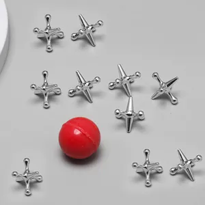 Metal jacks game set detail featuring shiny silver pieces and classic red bouncing ball toy.