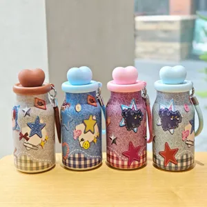 Botella de agua aislada de mezclilla creativa con tapa de corazón y correa.