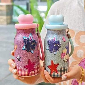 Primer plano detallado del bonito termo de mezclilla con tapa de corazón y parches de estrellas.