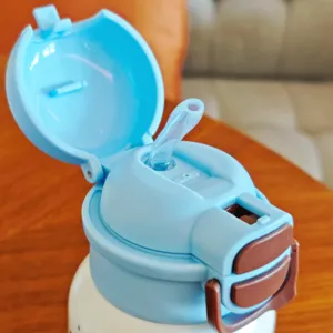 Dettaglio del coperchio borraccia bambini, design con tappo a scatto e cannuccia per la scuola.