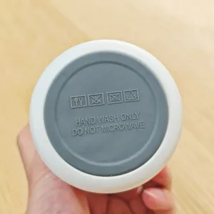 Bottom detail view of stainless steel insulated water bottle with hand wash warning and icons.