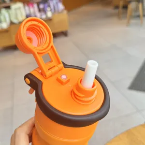 Portable outdoor sports water bottle detail view with orange and brown straw cup lid design.