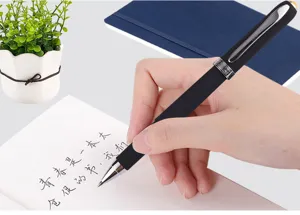 Close-up detail of black gel ink pen in hand writing on notebook, smooth writing tool.
