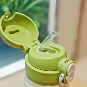 Close-up detail of green insulated water bottle lid with straw and secure locking button.