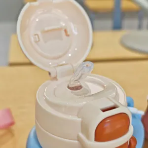 Kids thermos cup lid and straw detail close-up view, pink and white portable design.