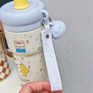 Borraccia termica con simpatico cartone animato, cannuccia portatile, cinturino e dettaglio.