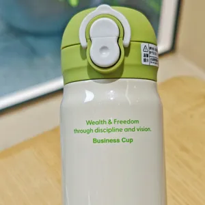 Stainless steel insulated water bottle with motivational text and green leak-proof lid detail.
