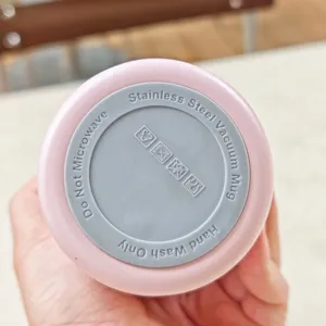 Detalle del fondo de la taza de acero inoxidable con instrucciones de cuidado e iconos