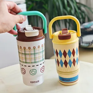 Close-up detail shot of portable stainless steel travel mugs with cute plaid and smiley design.