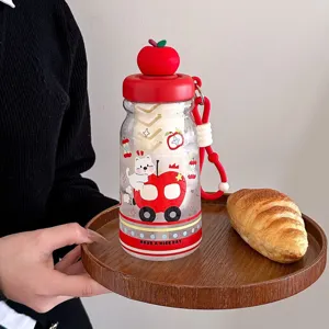Detailed view of cute apple lid plastic water cup with cartoon cat print and portable strap.