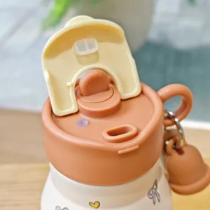 Gros plan détail couvercle bouteille isotherme portable et charmant pendentif.