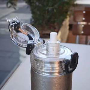 Detailed view showing the pop-up lid and straw of the stainless steel vacuum insulated cup.