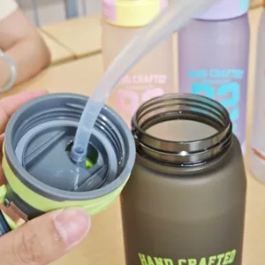 Frosted plastic water bottle detail, large capacity straw cup design for outdoor sports.