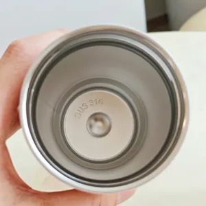 Close-up view of the smooth interior and bottom detail of a stainless steel thermos coffee cup.