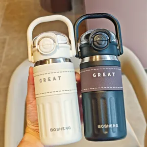 Stainless steel dual-drinking insulated water bottle with straw and portable handle detail.
