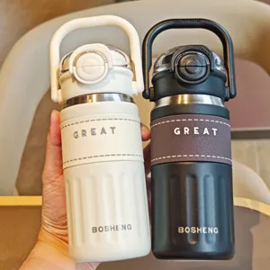 Stainless steel vacuum insulated water bottle with handle, portable dual-drink travel mug.
