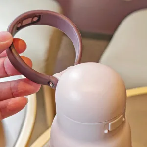 Primo piano del coperchio termico con cinturino in silicone e pulsante di apertura.