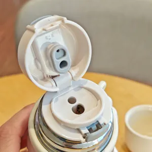 Stainless steel thermos cup detail shot showing the inner lid structure and dual holes.