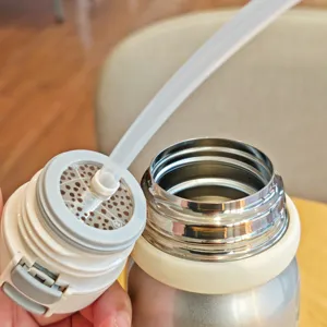 Stainless steel vacuum water bottle detail view showing straw lid and inner strainer structure.