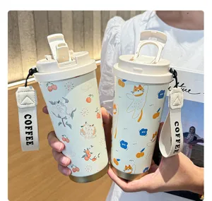 Vue détaillée de la tasse isolante portable en acier inoxydable avec motif de chat et sangle.