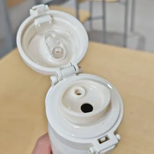Primer plano de la tapa del termo blanco con doble boquilla y anillo de sellado de silicona.