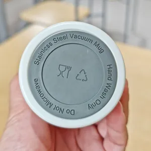 Vista detallada de taza de vacío de acero inoxidable, termo portátil con instrucciones en base.