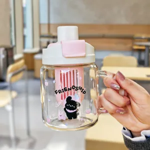 Detail view of the clear glass water bottle featuring a cute cartoon dog and handle design.