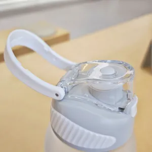Primo piano del coperchio della borraccia portatile con manico bianco e tappo flip-top sicuro.
