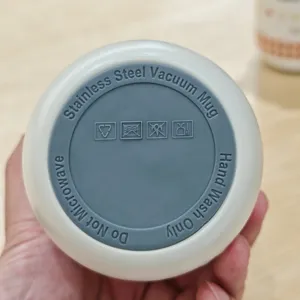 Stainless steel vacuum mug bottom detail view, showing hand wash and no microwave icons.