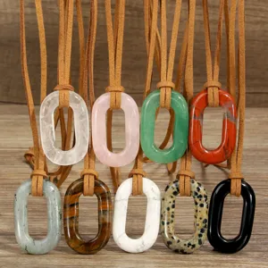 Detailed close-up of bohemian oval gemstone pendant necklace with brown suede leather cord.