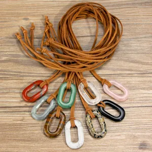 Detail shot of boho oval crystal gemstone pendant necklaces with long brown suede leather cords.