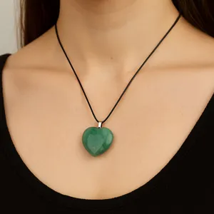 Green heart pendant necklace detail, green gemstone crystal jewelry accessory on black cord