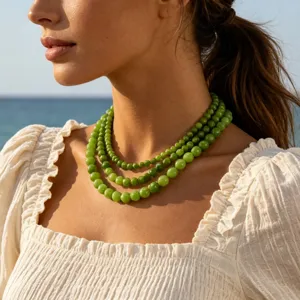 Primo piano dettagliato della collana di perle in pietra naturale verde indossata.