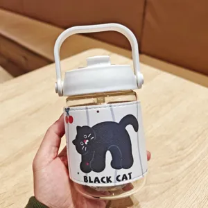 Portable glass water bottle with cute black cat leather sleeve, white handle and lid for daily use.