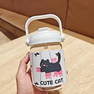 Detail view of cute cat glass water bottle with protective leather sleeve and straw lid.