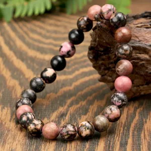 Close-up detail of natural gemstone beaded bracelet showing polished round bead texture and grains.