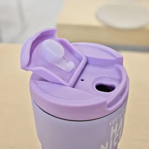 Close-up detail of the purple stainless steel travel coffee mug lid and spout mechanism clearly.