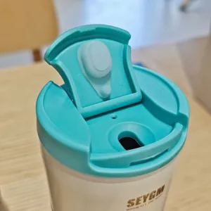 Stainless steel coffee mug replacement lid detail view, leakproof teal flip top travel tumbler cup