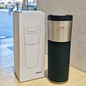 Stainless steel vacuum coffee travel mug detail with textured silicone grip and secure lid.