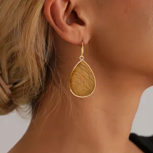 Primer plano detallado de pendientes colgantes de piedra natural en forma de gota.