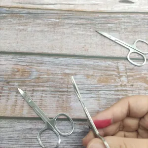 Détail rapproché d'une ciseaux de beauté en acier inoxydable à lame courbe pour sourcils fins