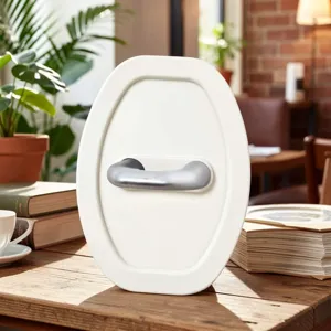 White oval cabin window style home decor ornament with a silver metal handle on a wooden desk.