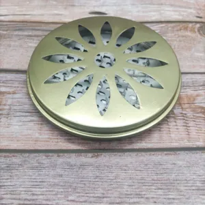 Gros plan détaillé du couvercle de porte-encens en métal doré avec motif ajouré.