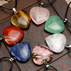 Detailed shot of multi-color gemstone heart pendant necklaces on dark wood background