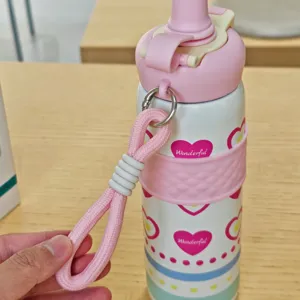 Stainless steel insulated water bottle detail with pink heart design and strap.