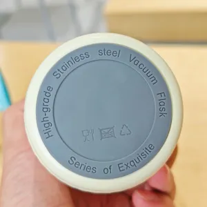 Edelstahl Vakuumbecher Boden Detailansicht, tragbarer Kaffeetasse mit Sicherheitssymbolen.